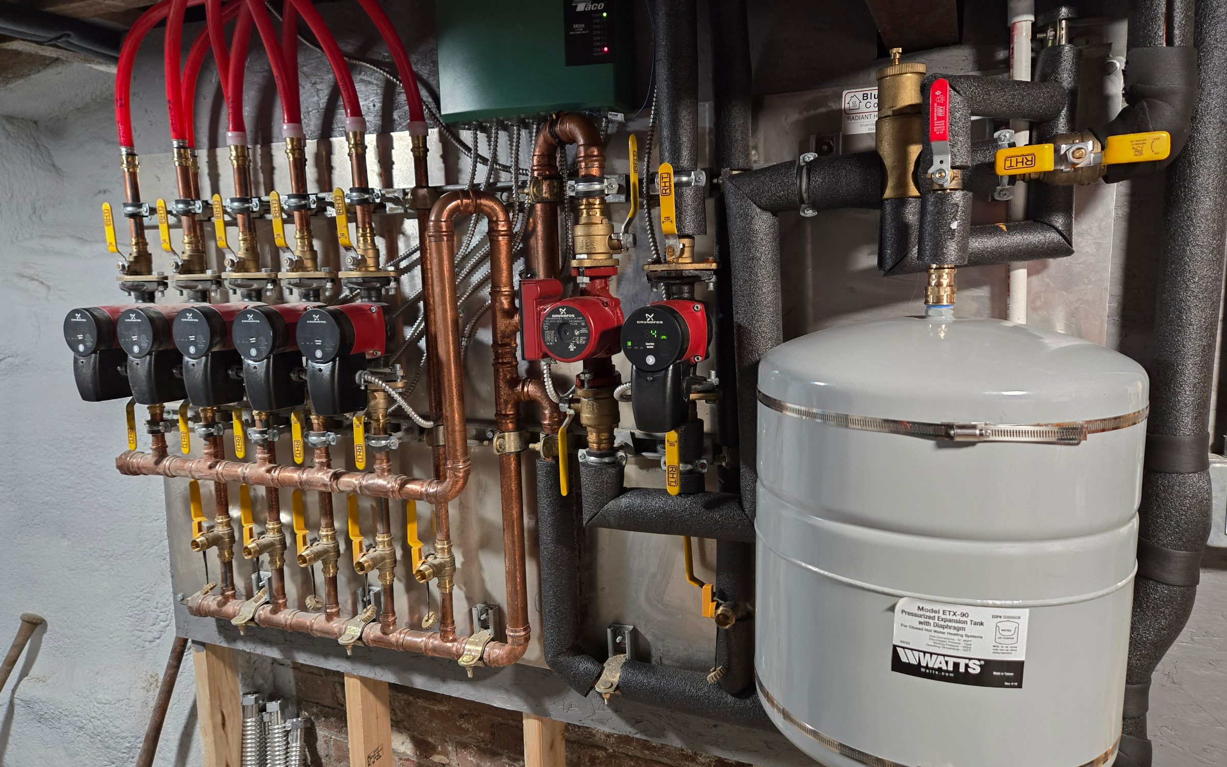Radiant heating manifold with zone valves and expansion tank installed by Primrose