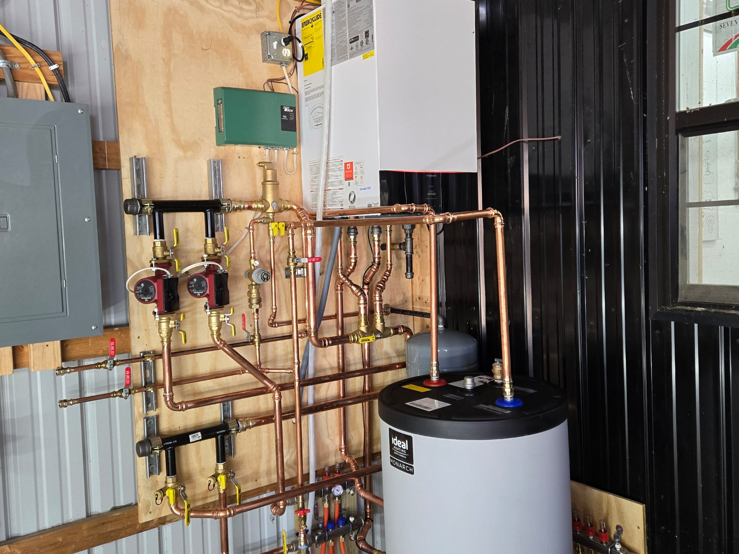 Copper manifold, water heater and electrical panel in a basement mechanical room